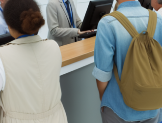 Passengers lining up at an airline customer service desk to discuss their rights