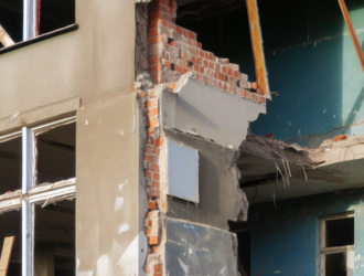 An old building being torn down, revealing the use of asbestos materials